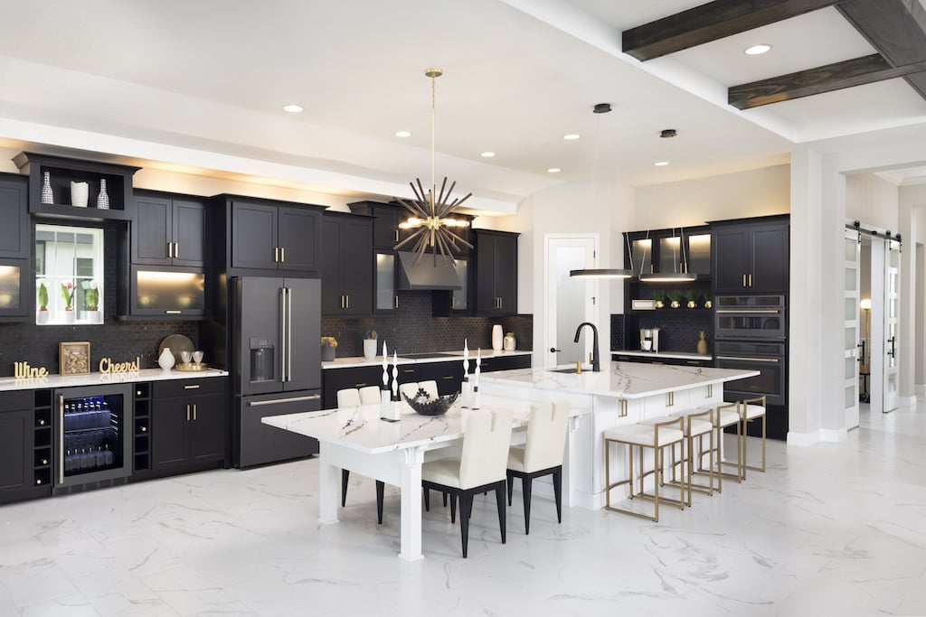 Open concept ktichen with recesse lighting, dark fabinets, and white island